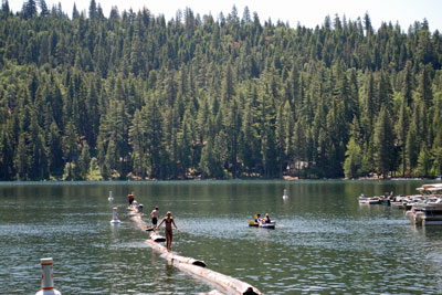 Photo of two people and their dog on paddleboards at Pinecrest Lake, CA